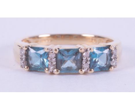 A yellow gold ring set with three square cut blue topaz, total weight approx. 1.17 carats, interspaced by small round brillia