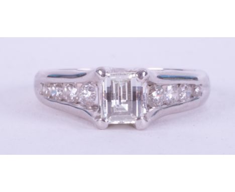 An 18ct white gold ring set centrally with 0.80 carats of an unusual fancy rectangular cut diamond with four round brilliant 