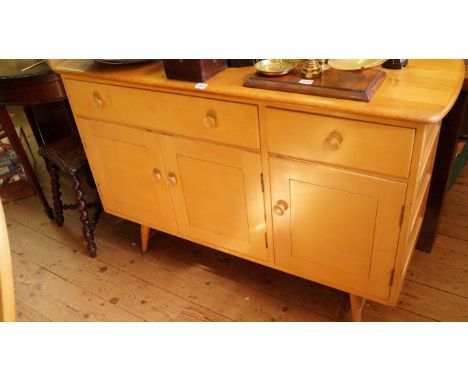 An Ercol dining suite, comprising a table, six chairs and a sideboard. 