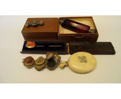 An unmarked oval stick pin having a carved coral head; together with a carved stone bracelet and brooch; a  ruby glass double