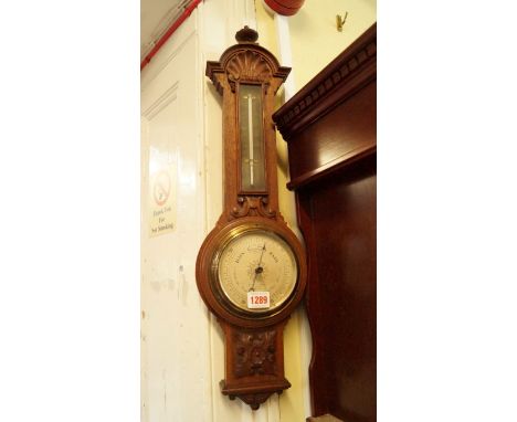An early 20th century carved oak wheel barometer, by Negretti & Zambra, 65cm high. 