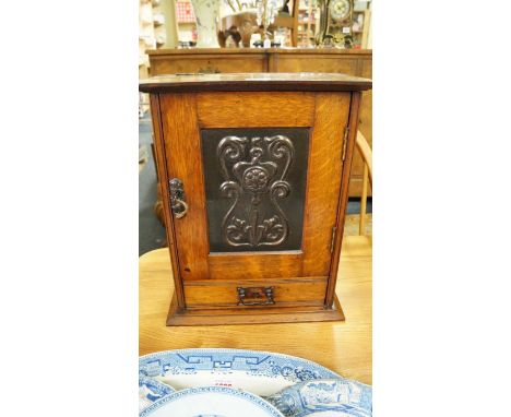 A circa 1900 oak and embossed copper smoker's cabinet, with an Art Nouveau copper inset door panel, 32cm wide.