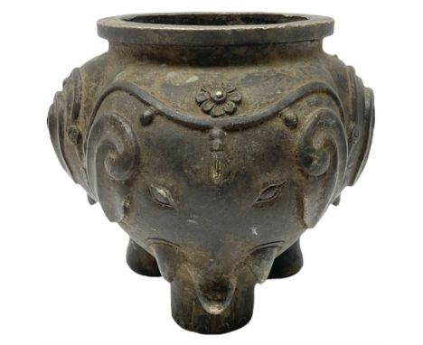 Chinese Qing dynasty bronze elephant censer, of tripod form, the lobed body cast as the heads of three elephants with floral 