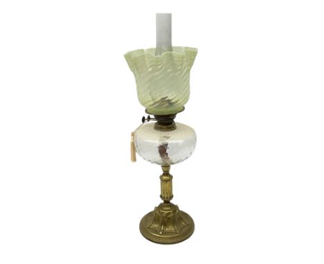 19th century brass oil lamp, the green vaseline glass shade of wrythen and frill form above a clear glass reservoir, raised u