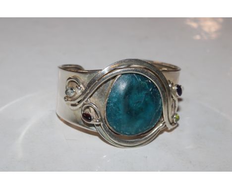 A large Sterling silver peridot, garnet, moonstone and amethyst set cuff bangle, approx. 43gms 