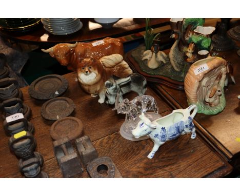 A Coopercraft study of a highland cow; another of a dog; a porcelain donkey figure; a glass model of an elephant and a cow cr