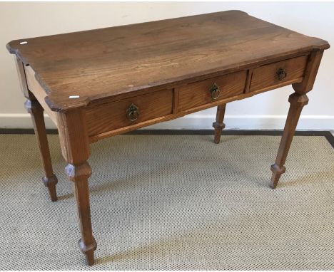 A Victorian Gothic Revival pitch pine side table, the top with chamfered edge over three frieze drawers with brass rope work 