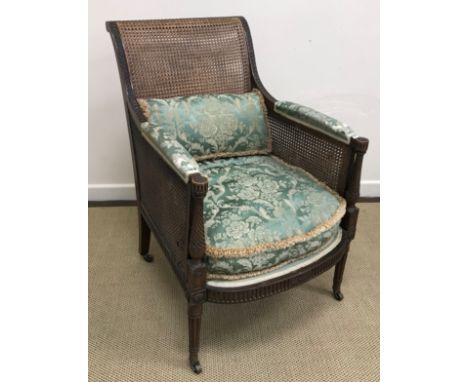 A circa 1900 mahogany framed and double caned Bergere armchair in the Regency style with guilloche, barley twist and fluted c