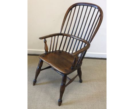 A 19th Century ash and elm stick back Windsor type elbow chair on turned and ringed legs united by an H stretcher raised on p