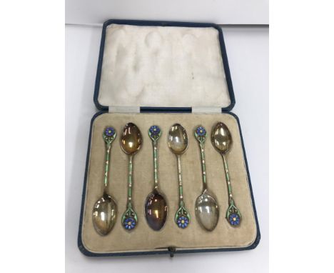 A cased set of six George V silver and enamel decorated coffee spoons, each with floral set finial (by Turner &amp; Simpson L