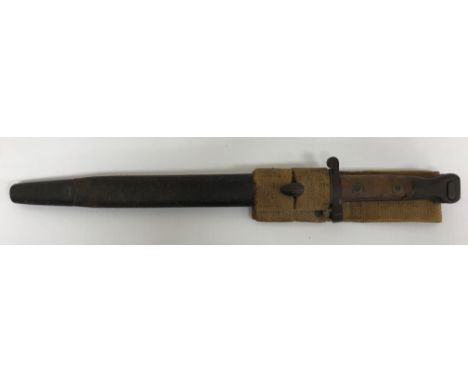 An 1888 pattern bayonet with wooden handle and brass fittings, the blade engraved, housed in a leather scabbard with canvas b