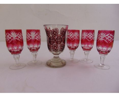 A Bohemian overlaid glass with ruby roundels on raised circular foot and five Venetian cranberry wine glasses