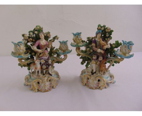A pair of continental porcelain two light candelabra in the rococo style on raised pierced bases A/F