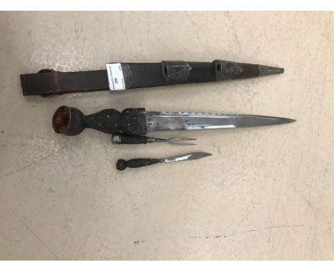A 19th century Scottish dirk, with carved oak handles and Niello-worked white metal fittings, faceted foil backed stones: the