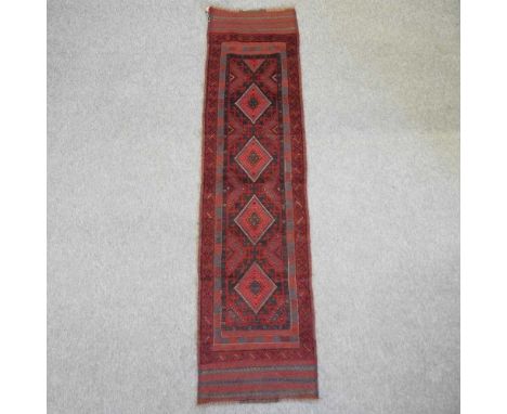 An Afghan runner, with four central medallions, on a red ground242 x 60cm