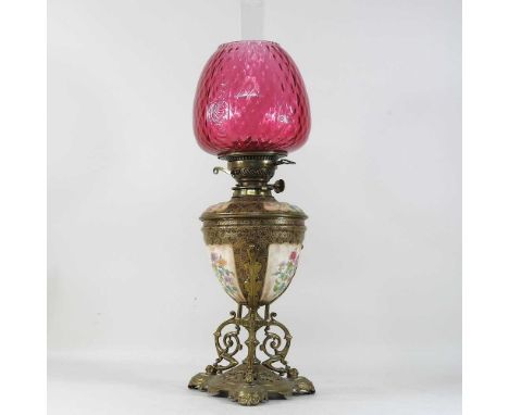 A 19th century Doulton brass mounted oil lamp, reserved with floral panels, on an ornate scrolled base, printed marks, with a