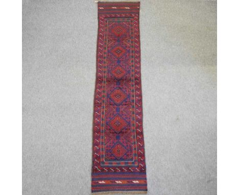 An Afghan runner, with six central medallions, on a red ground260 x 59cm
