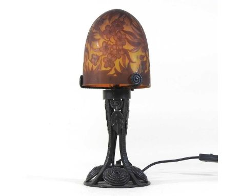 A Daum style iron table lamp, with a cameo glass shade, decorated with flowers38cm high
