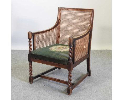 A 1920's oak single cane bergere chair, with a green cushion seat62w x 66d x 93h cmCondition report: Overall solid and usable