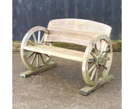 A wooden garden bench, with cartwheel supports100cm wide