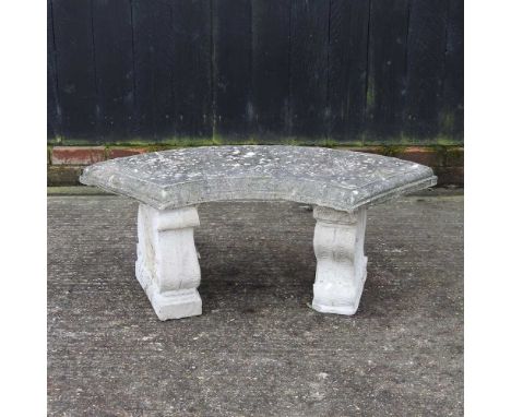 A reconstituted stone garden bench, of curved shape, on scrolled supports105cm