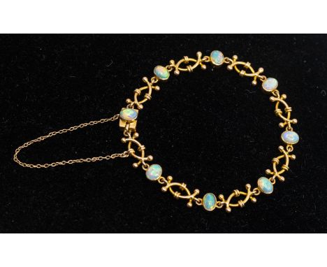 An early 20th century opal and 15ct gold bracelet, comprising oval cabochon opals each approx 5x3mm, with alternate fancy lin