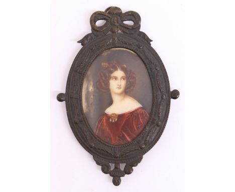 A 19th century oval portrait miniature of a lady wearing red robe dress with elaborate jewelled clip, in probably later gilt 