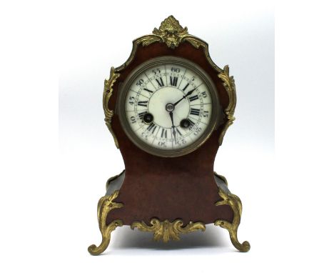 A 20th century French walnut veneered and gilt metal mounted mantle clock, raised on scroll feet; the white dial with twin wi