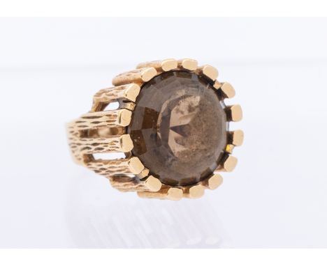 A large modernist smoky quartz and 9ct gold ring, comprising a round mixed cut quartz approx 15mm, within a textured mount, s