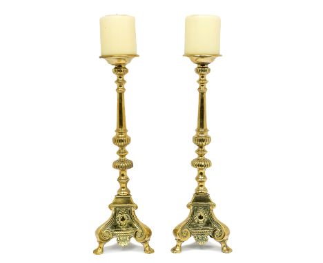 A pair of 19th century ornate brass candle holders, of Neo-Classical style with shell and foliate deisgned scrolled tr-pod ba