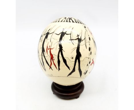 A South African painted Ostrich egg, painted with tribesmen hunting with bows and arrows, with signature to base "MAFO", appr