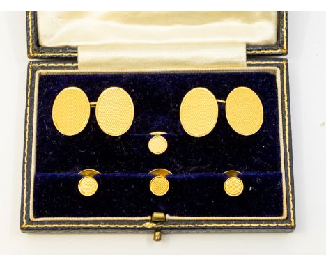 A gentleman's cased 18ct gold cufflink set, dated 1887, comprising a pair of oval engine turned cufflinks, along with large s