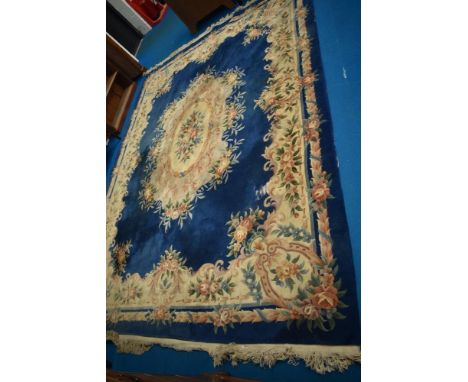 A vintage Chinese carpet square having blue ground with floral pattern and fringed edge, approx 370cm by 275cm.