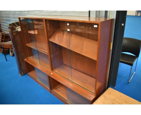 A pair of vintage teak bookcases with cupboards to base