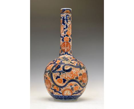 Japanese Imari bottle vase, having partial relief decoration depicting dragons amongst scrolling foliage in iron-red, blue an