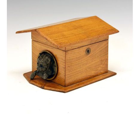 Late 19th/early 20th Century oak tea caddy, formed as a dog kennel having spelter figural decoration depicting a terrier peer