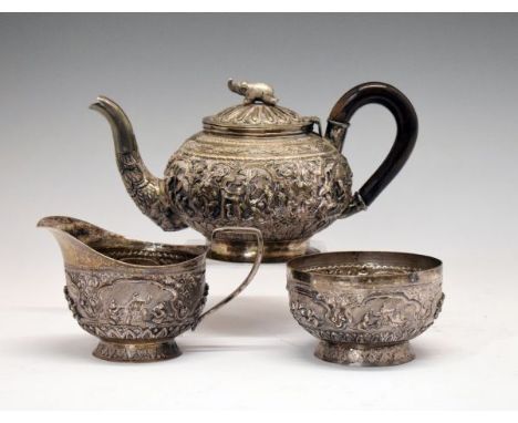 Late 19th/early 20th Century Burmese white metal three piece tea service, comprising: teapot, sugar bowl and milk jug, the fo