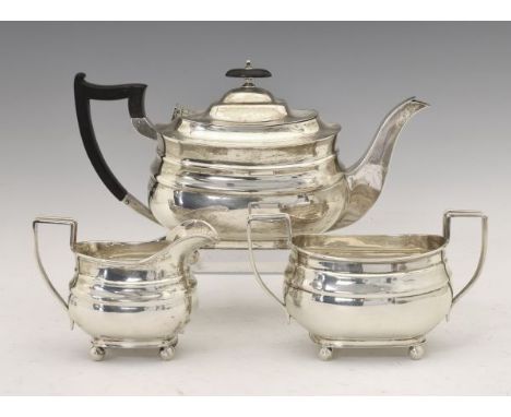 George V silver three piece tea set, of London shape, each piece standing on ball feet, sponsors mark of William Hutton &amp;