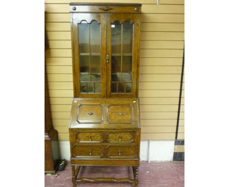 An early 20th Century Jacobean style oak bureau bookcase, the twin glazed bookcase doors with double arch moulding, adjustabl