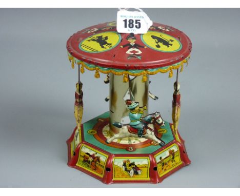 A vintage tinplate clockwork merry-go-round with children riding animals, colourful lithograph decoration, in good condition 