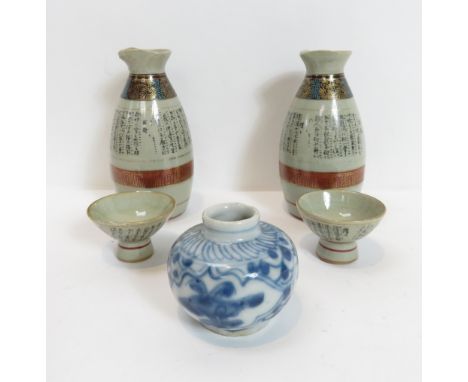 A pair of Japanese Saki bottles painted with character text, two similar saki cups and a small blue and white vase