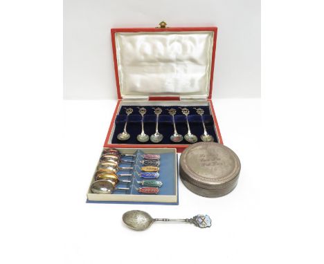 A silver spoon with enamel finial of a target and crossed rifles; a cased set of white metal spoons with camel finials; a cas