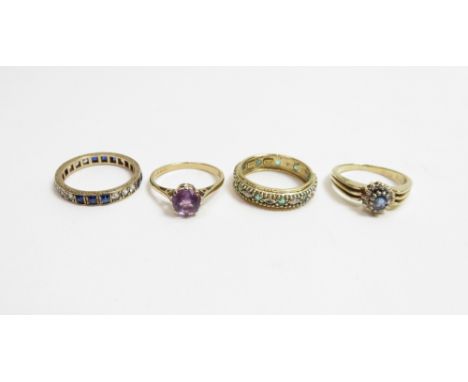 A 9 carat gold blue topaz and diamond ring; a 9 carat gold single stone amethyst ring; and two eternity rings, stamped '9ct' 
