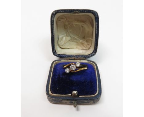 A three stone diamond crossover ring, indistinct mark, the graduated old cuts totalling approximately 0.35 carats, finger siz