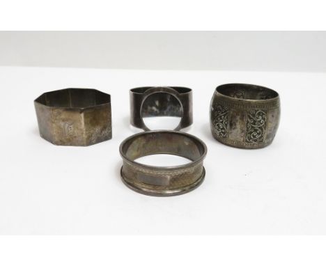 An octagonal silver napkin ring; another silver napkin ring; a narrow silver napkin ring; and a white metal napkin ring, poss