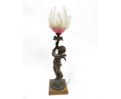 A late 19th century spelter figure of cupid holding aloft a floral bough, converted for use as a lamp and with glass flower h