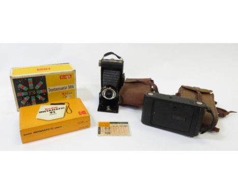 A Kodak folding Brownie camera in carrying case; Kodak autograph folding camera in case and two Instamatics in boxes