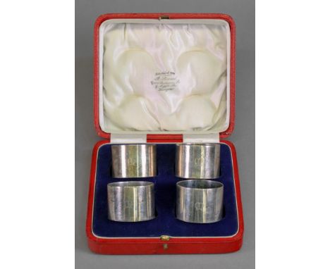A cased set of four circular silver napkin rings, E S Barnsley &amp; Co, Birmingham 1921, numbered 1-4, initialled 'M', 5.2oz