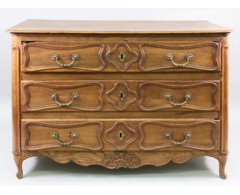 A Louis XV provincial oak commode, of panelled construction, the moulded rectangular top above three long drawers with quatre