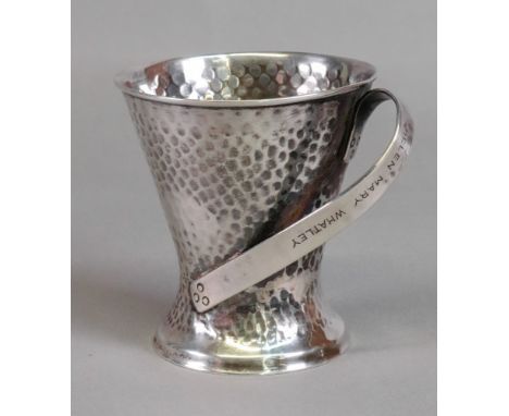 An Art Nouveau silver christening mug, Samuel Jacob, London 1905, spot hammered, of waisted tapering form with strap handle, 